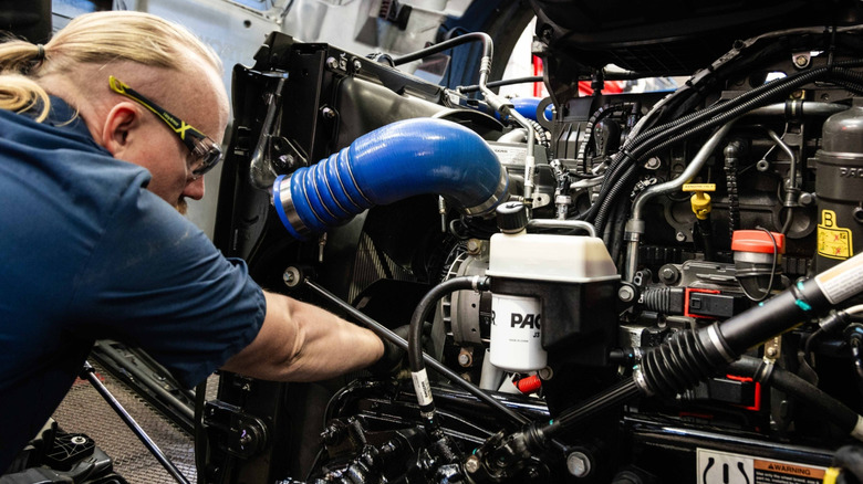 Worker checking PACCAR engine in a factory