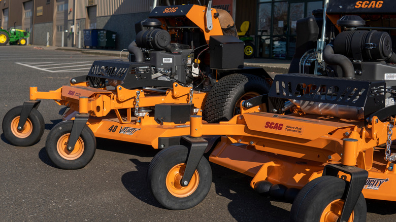 Orange Scag stand-on mowers shown outside a storefront