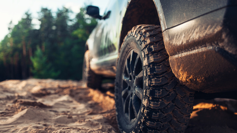SUV car at the off road close up view of the wheel