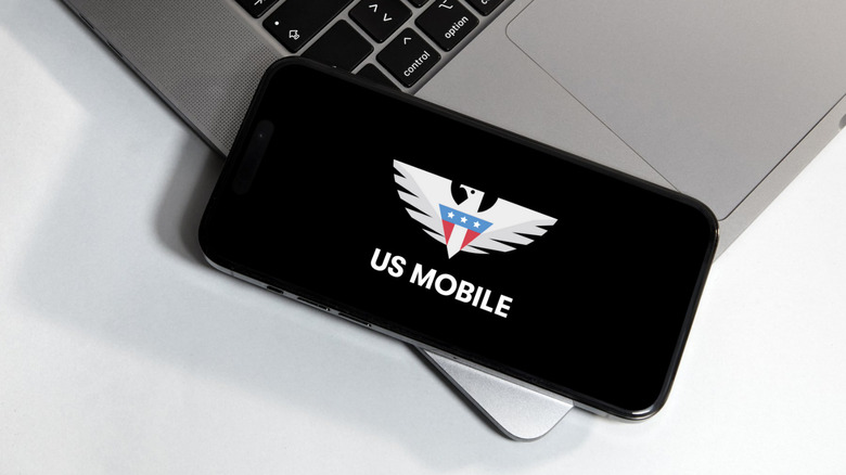 Mobile phone on a laptop keyboard showing the US Mobile logo