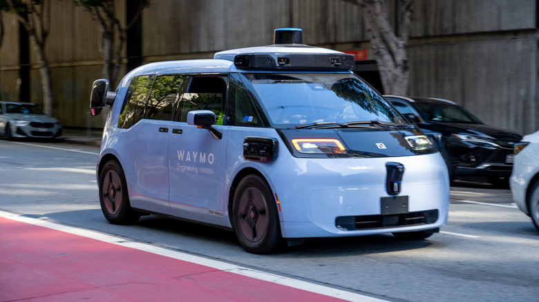 The Waymo Zeeker test vehicle, seen slightly blurred in motion, during autonomous vehicle testing