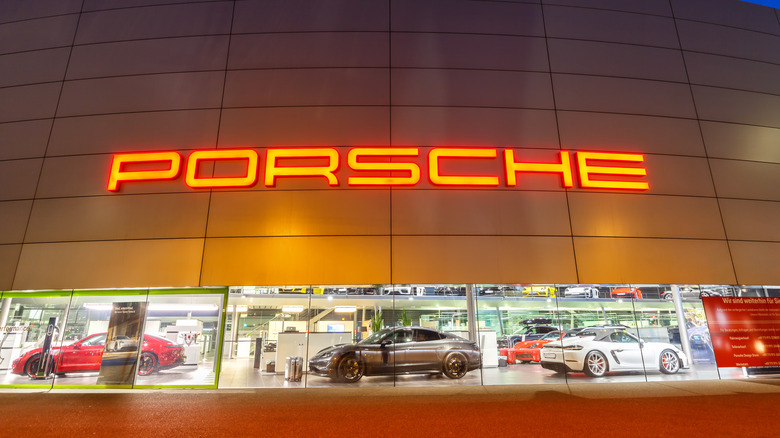Uma concessionária da Porsche à noite, com vários modelos em exibição no Windows