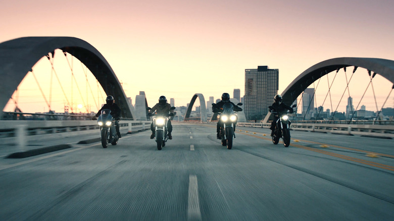 People riding Zero Motorcycle over bridge