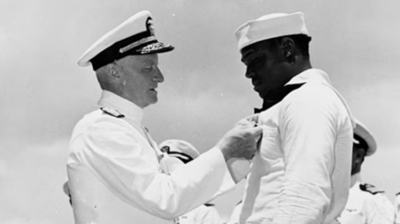 Navy Admiral Chester Nimitz awards the Navy Cross medal to Mess Attendant 2nd Class Doris Miller in 1942.