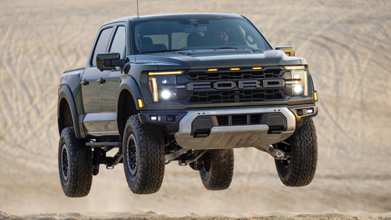 Front 3/4 view of Ford F-150 Raptor in mid-air in desert setting