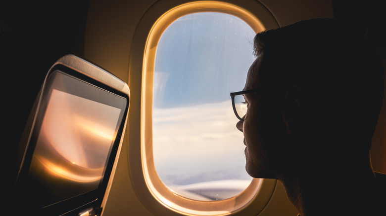airplane passenger looking out side window