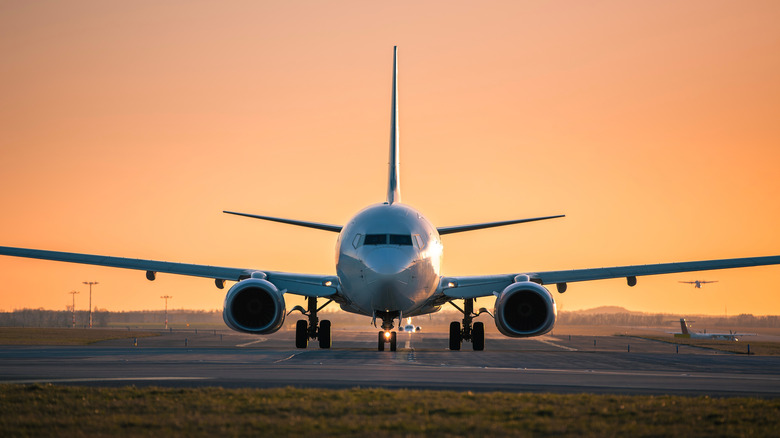 Two-engine plane on the runway during sunset