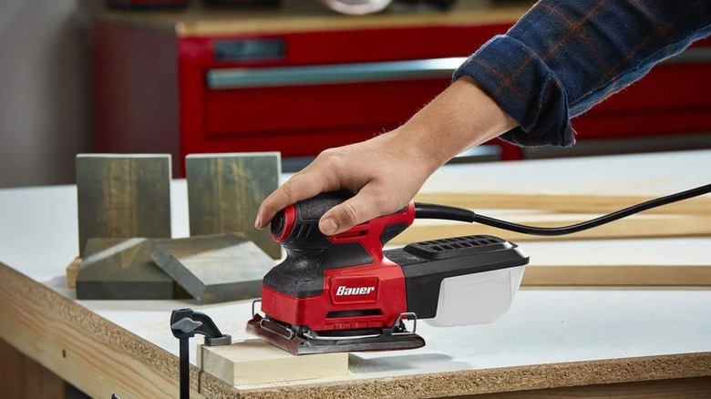 Using a Bauer sheet sander on a block of wood