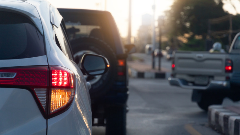 A white car in traffic shows a right-hand turn signal.