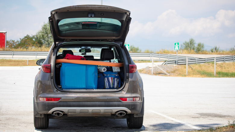 car trunk open showing luggage inside