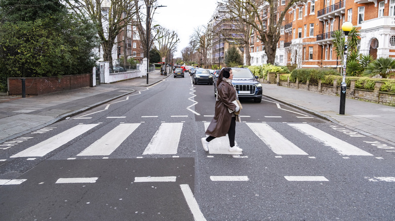 A woman crossing road using the zebra crossing on Abbey Road