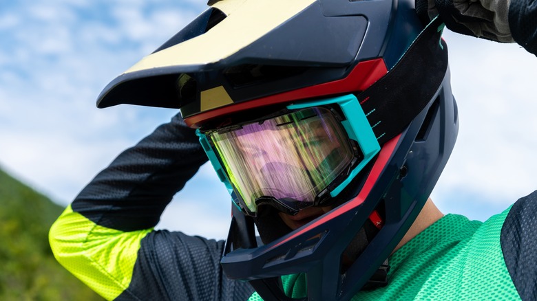 Rider adjusting dirt bike helmet