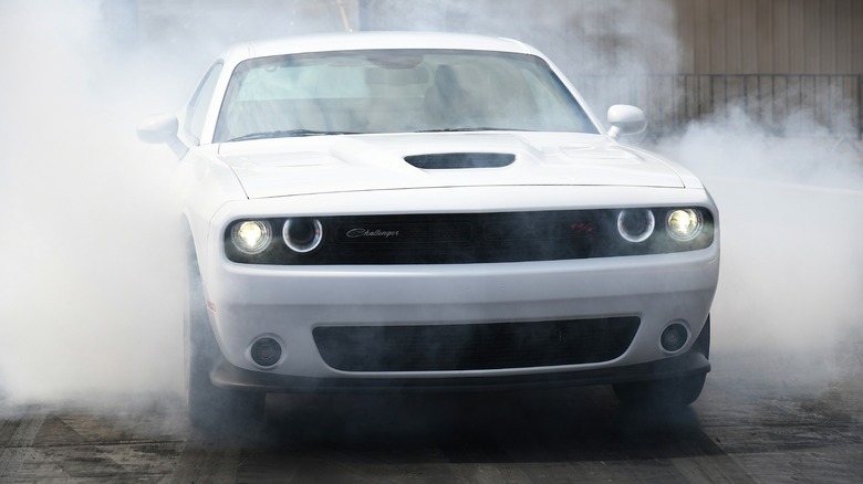 Front view of a white Dodge Challenger Scat Pack doing a burnout