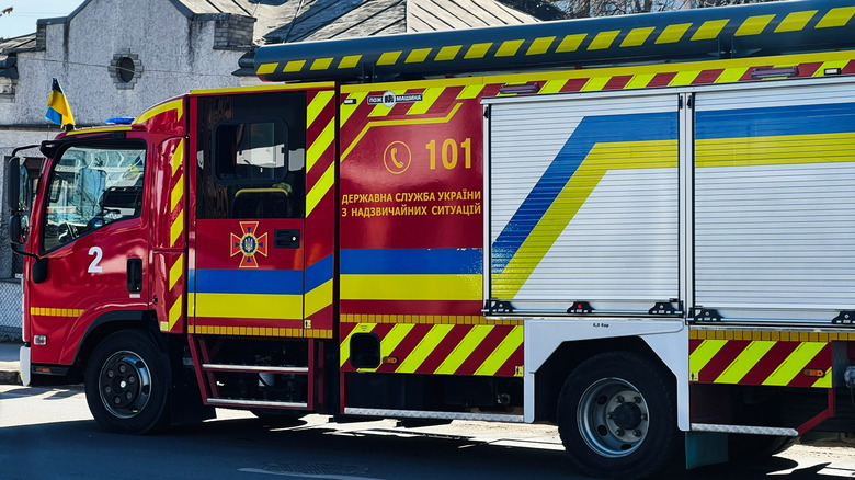 A red-colored fire truck with yellow strips on it.