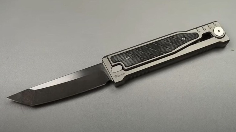 Titanium gravity knife fully open on steel table