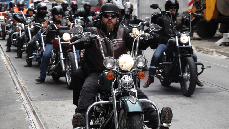 Multiple motorcycle gang members riding cruiser bikes down the street