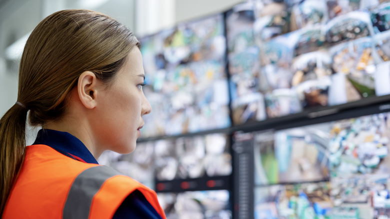 Woman in safety vest looking at screens