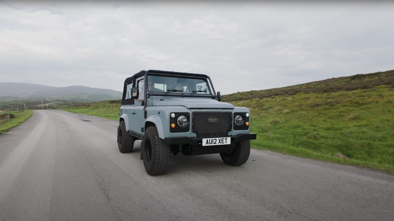 A blue restomod Land Rover Defender 90 by Mahker Workshop, front 3/4 view