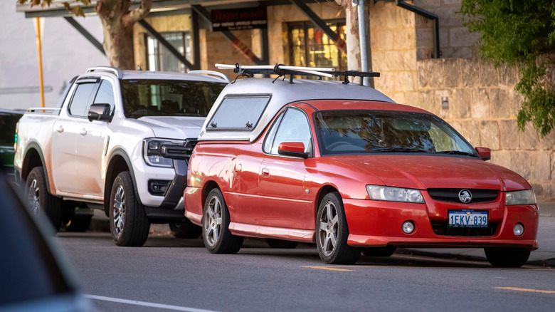 A Red Holden ute parked in front of a white Ford Ranger