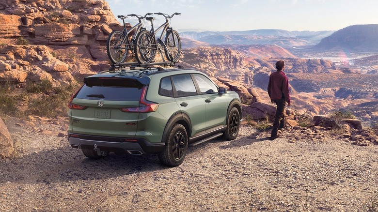 An ash green metallic TrailSport Honda CR-V Hybrid shown parked by a cliff