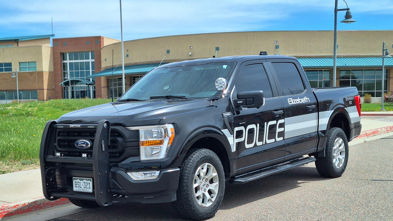 Ford pickup truck police vehicle parked in front of a building