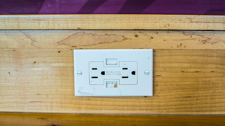 Sideways electrical outlet in wooden trim panel