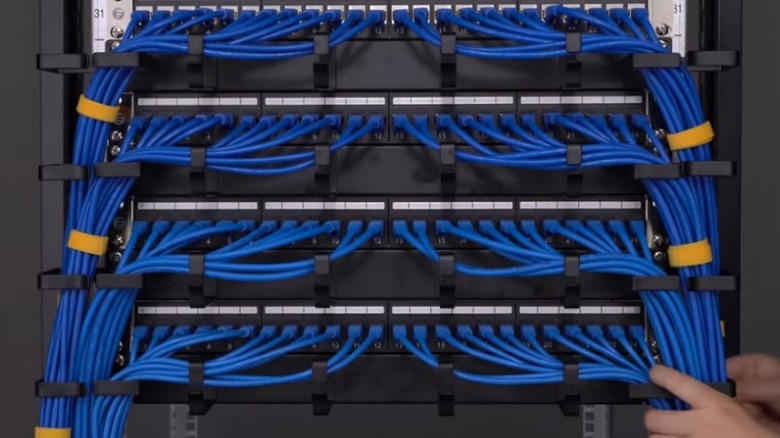 Person attaching blue ethernet cables