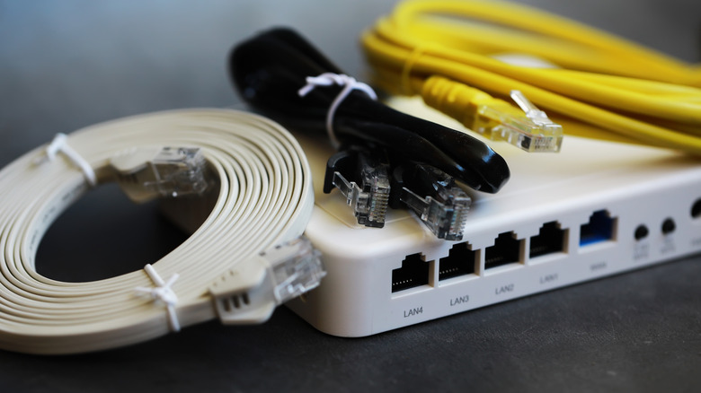 Router with flat and round Ethernet cables placed on top of it