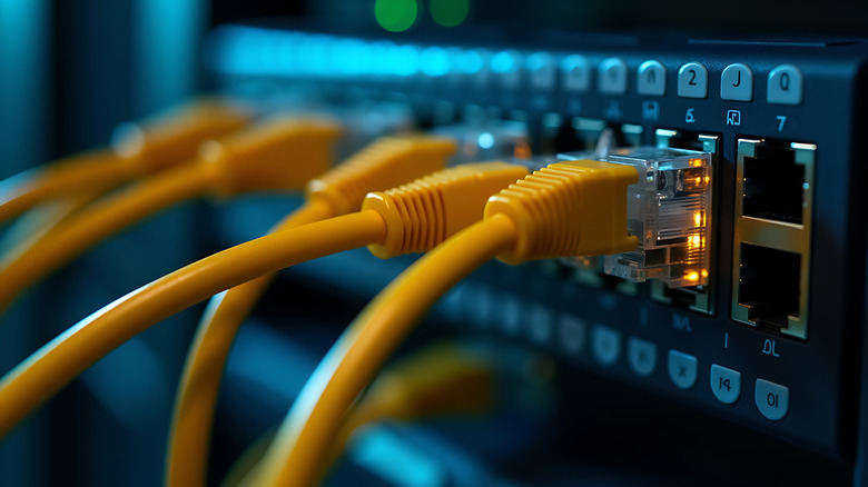 Close up of a network switch with multiple yellow ethernet cables connected