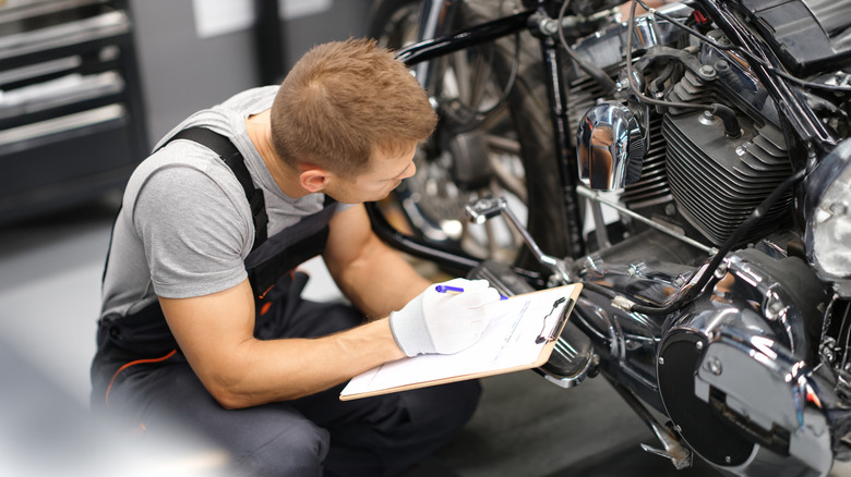 A service technician examining a motorcycle