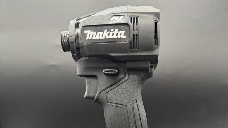 A black Makita impact driver against a black background.