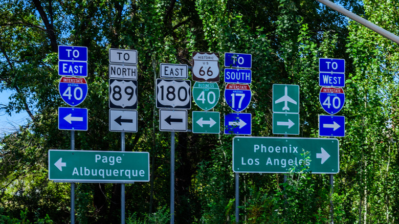 Large cluster of road signs with a mix of uppercase and lowercase lettering