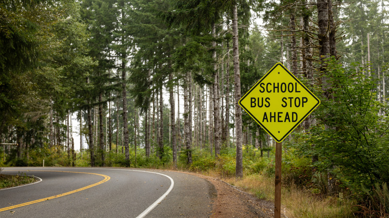 Warning sign indicating school bus stop ahead.