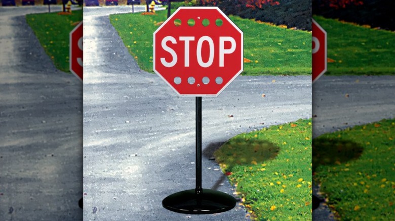 A perforated stop sign near a junction