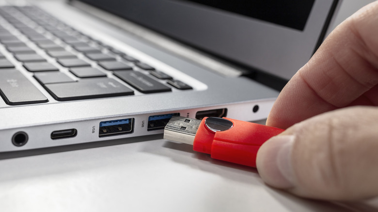 person plugging cable into USB port
