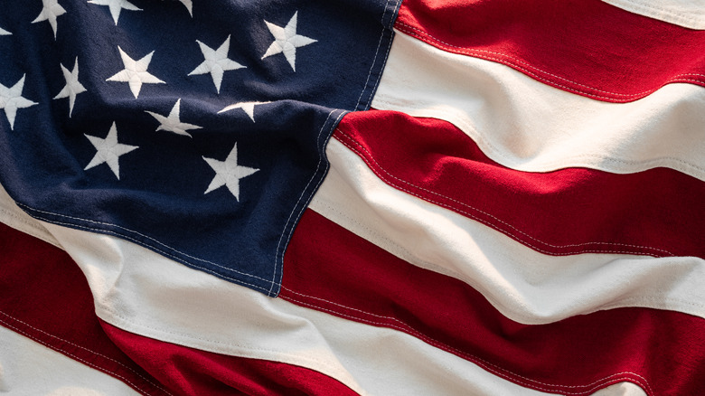 Extreme closeup of an American flag, with part of the star field and part of the stripes showing.