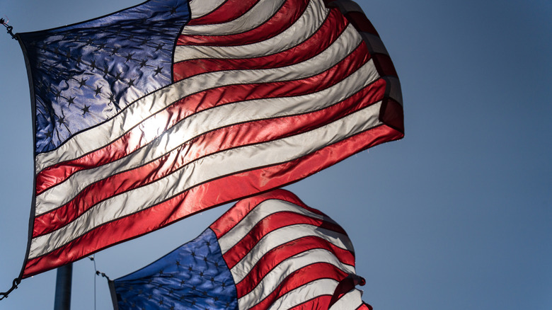Two american flags flap in the breeze.