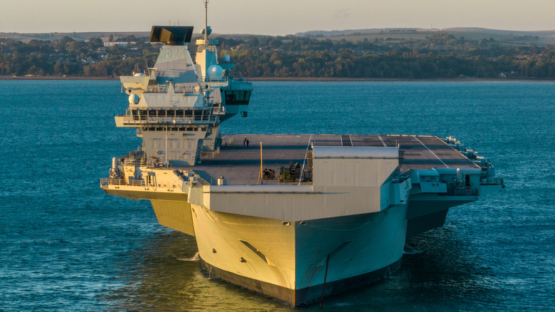 Tthe HMS Prince of Wales aircraft carrier anchored in the water.
