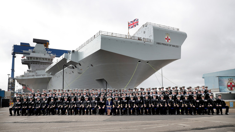 Group photograph in front of the HMS Prince of Wales aircraft carrier.