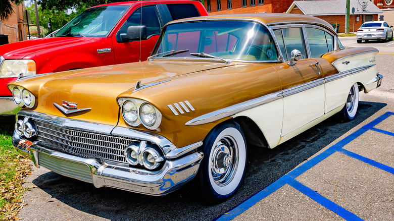 A 1957 Chevrolet Bel Air with a wraparound windshield in a parking lot.