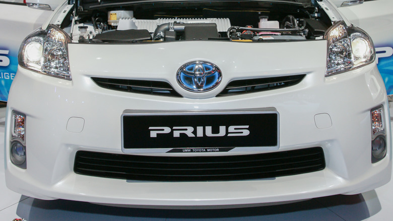 Front view of 2010 Toyota Prius with blue Toyota logo on display at auto show.