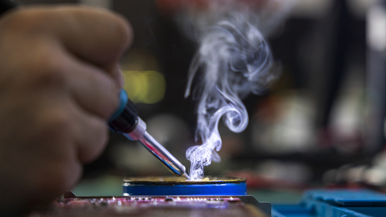 Technician soldering a motherboard