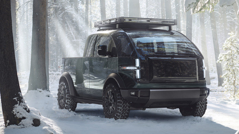 Canoo pickup truck parked in snowy forest