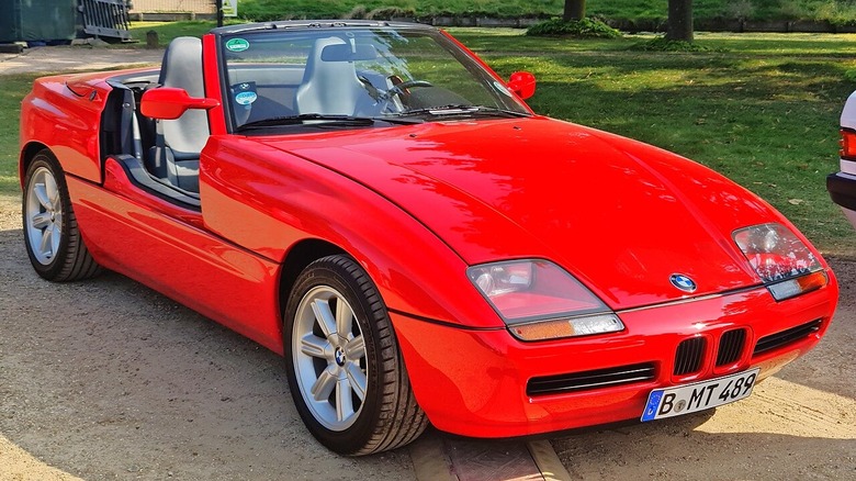front view of red BMW Z1 convertible in parking lot with grass and trees behind