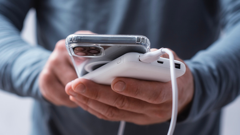 Close-up of a man charging his cell phone with a portable power bank