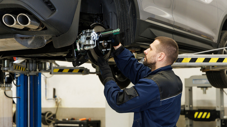 A mechanic repairing a car's brakes