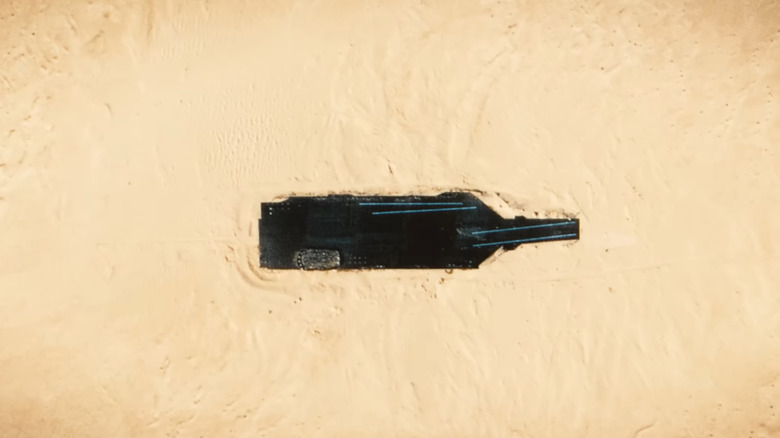 Satellite image showing a replica of the USS Gerald R. Ford in the desert during the day