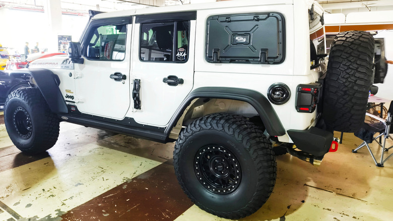 The vehicle features aftermarket modifications such as oversized tires and a lift kit