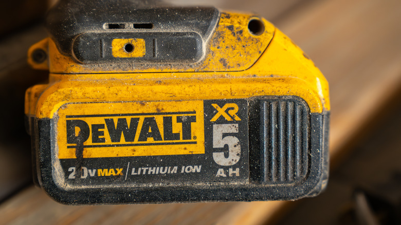 A dirty DeWalt XR 20V Max battery pack attached to an unidentified cordless DeWalt tool
