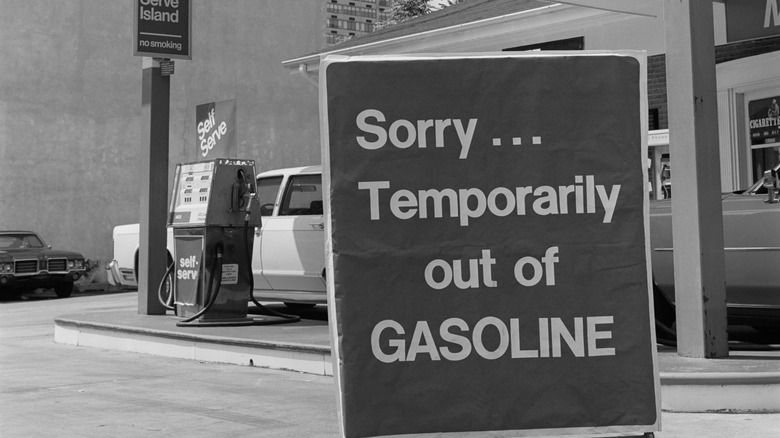 Gas station with sign reading, "Sorry... Temporarily out of Gasoline" in foreground